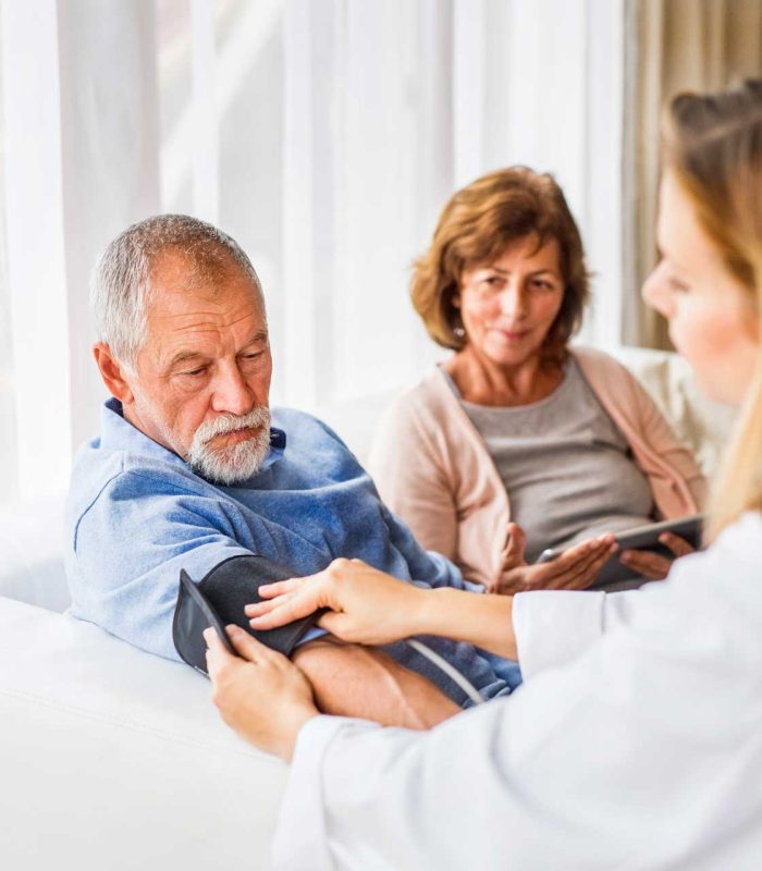female-doctor-checking-blood-pressure-of-senior-ma-PDN3YZZ.jpg