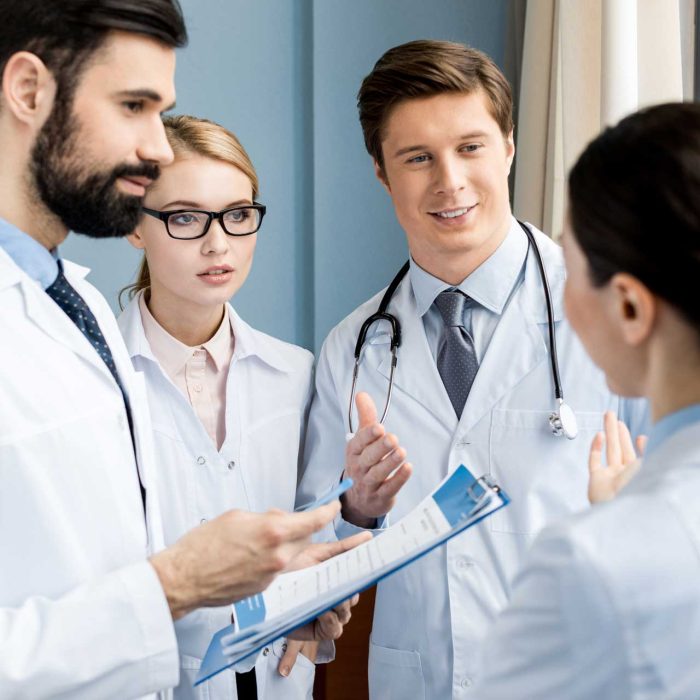 side-view-of-doctors-team-discussing-diagnosis-in-H9FJMNX.jpg